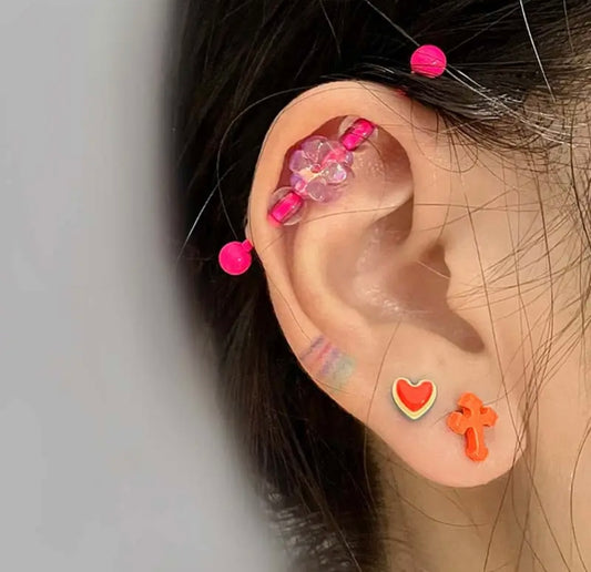14G Pink Flower Industrial Bar Earring On Person's Ear